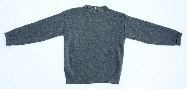 A grey wool sweater laid flat, the kind of item handed in every week